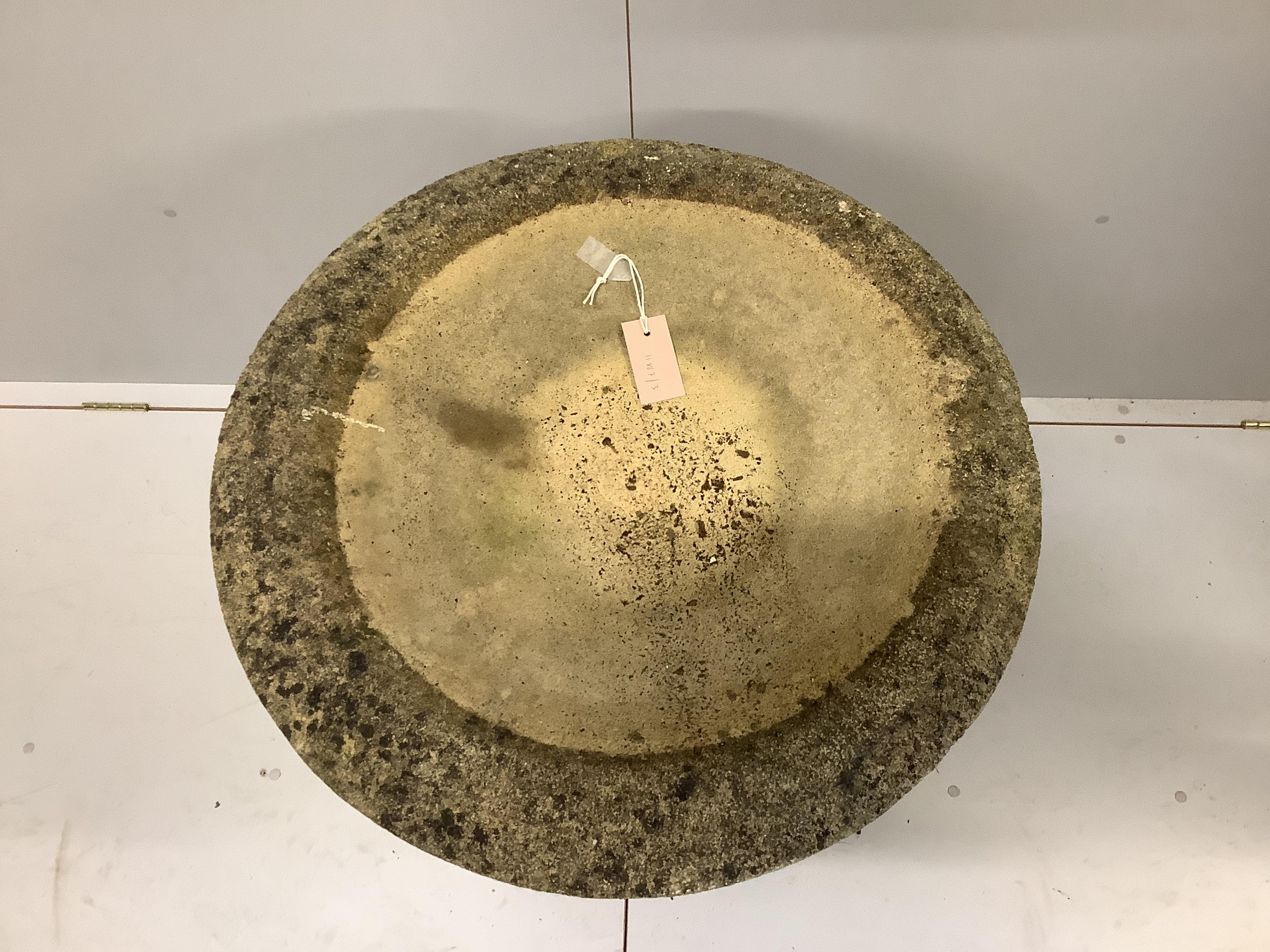 A circular stone bird bath on square plinth, diameter 58cm, height 95cm.